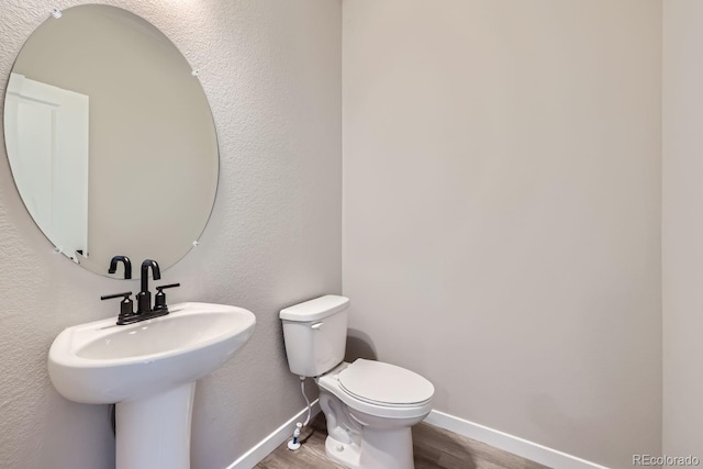 bathroom featuring hardwood / wood-style flooring, sink, and toilet