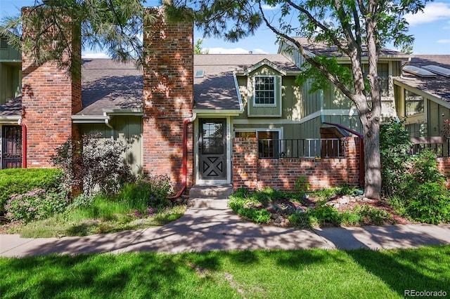 11704 Elk Head Range Rd, Littleton, CO 80127 - english style home featuring a chimney, roof with shingles, and brick siding