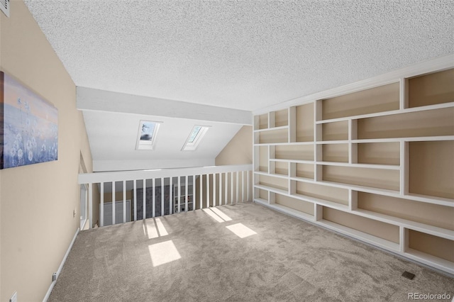 11704 Elk Head Range Rd, Littleton, CO 80127 - additional living space with carpet, a textured ceiling, lofted ceiling, and a skylight