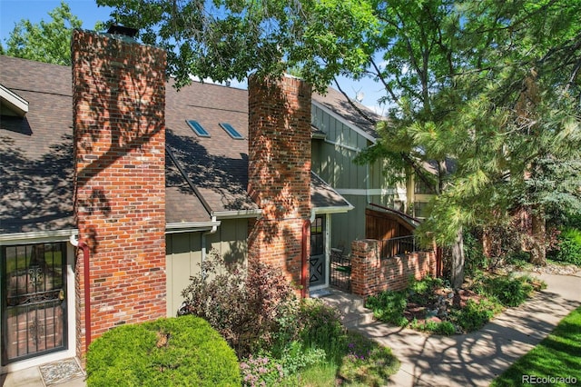 11704 Elk Head Range Rd, Littleton, CO 80127 - view of home's exterior featuring a chimney, roof with shingles, and a gate