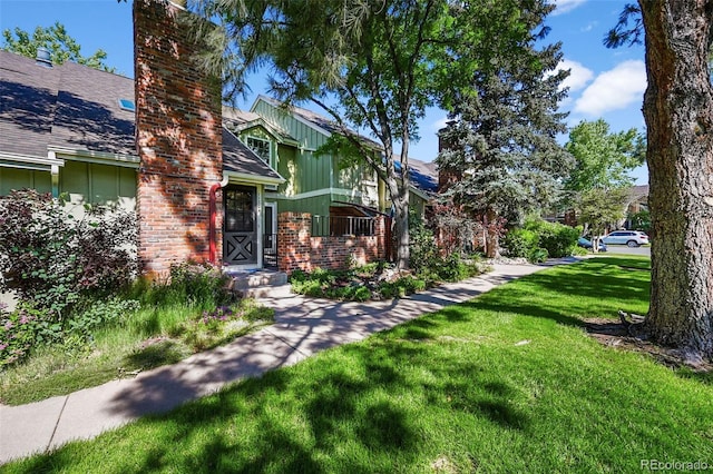 11704 Elk Head Range Rd, Littleton, CO 80127 - view of front of home with a front lawn, brick siding, and a chimney