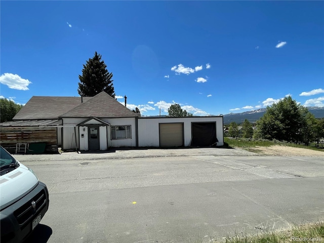 view of front facade with a detached garage and a mountain view