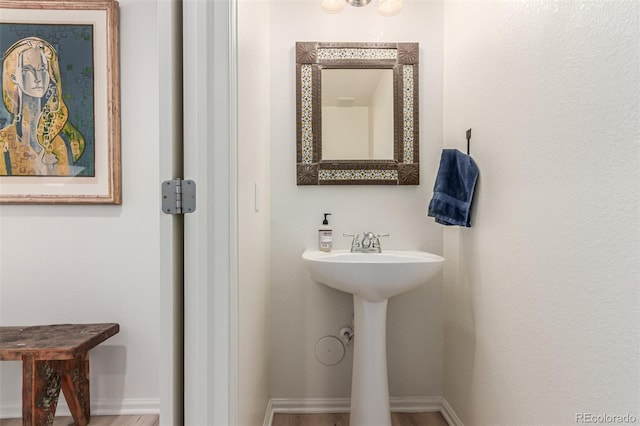 bathroom with baseboards, a sink, and wood finished floors