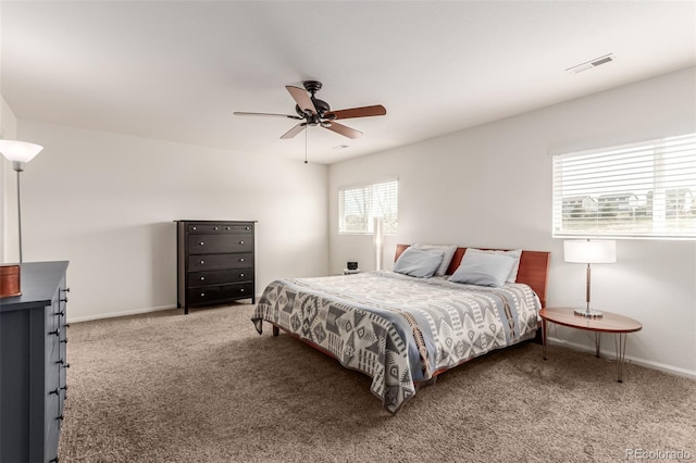 bedroom with carpet, visible vents, multiple windows, and baseboards
