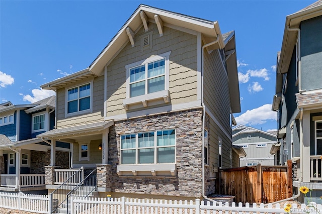 13736 Umatilla Ln, Broomfield, CO 80023 - view of front of property with stone siding, a fenced front yard, and covered porch
