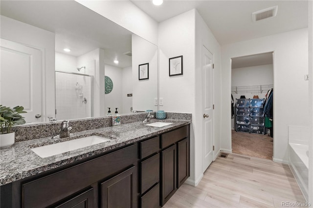 bathroom featuring separate shower and tub, vanity, and wood-type flooring