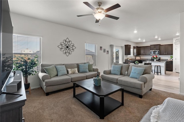 living room with light hardwood / wood-style floors, plenty of natural light, and ceiling fan