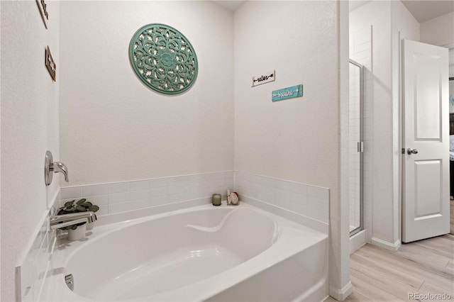 bathroom with hardwood / wood-style floors and separate shower and tub