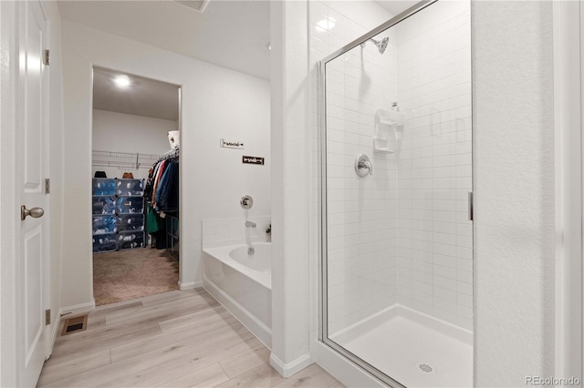 bathroom featuring independent shower and bath and wood-type flooring