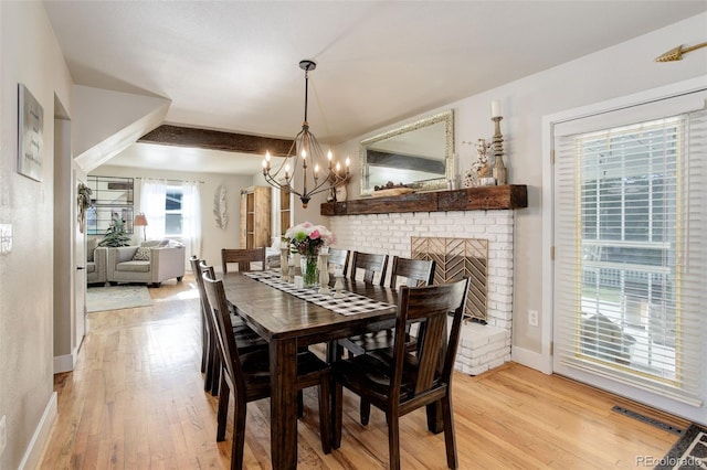5332 W Roxbury Pl, Littleton, CO 80128 - dining space featuring a chandelier, light wood-type flooring, baseboards, and a brick fireplace
