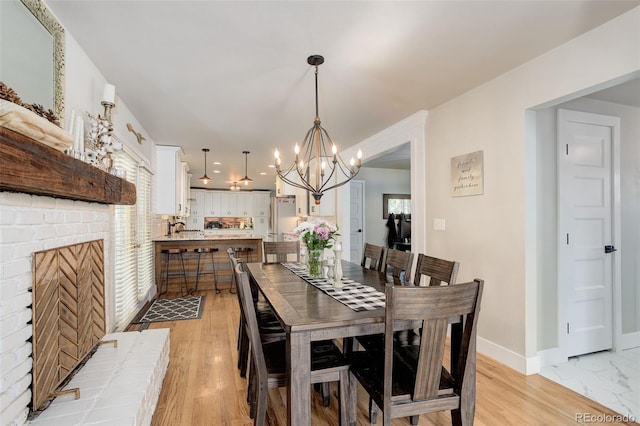 5332 W Roxbury Pl, Littleton, CO 80128 - dining room featuring a chandelier, baseboards, and a fireplace