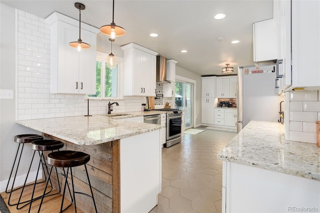 5332 W Roxbury Pl, Littleton, CO 80128 - kitchen with wall chimney exhaust hood, stainless steel appliances, a peninsula, backsplash, and a sink