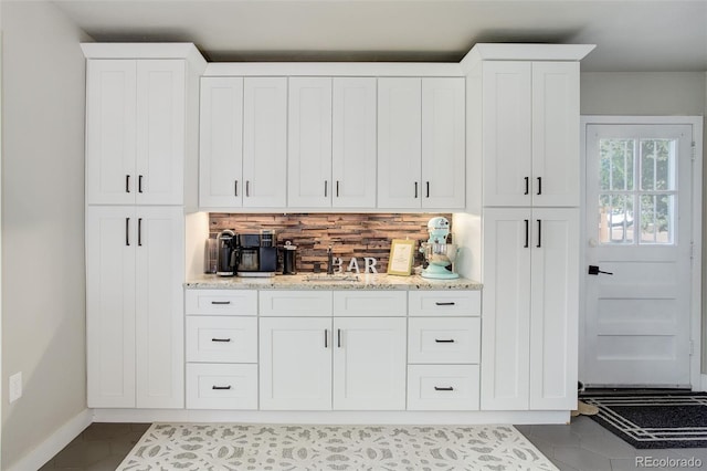 5332 W Roxbury Pl, Littleton, CO 80128 - kitchen with backsplash, a sink, white cabinets, and baseboards