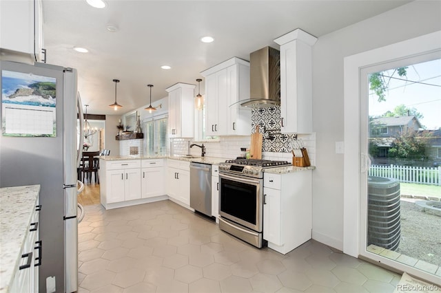 5332 W Roxbury Pl, Littleton, CO 80128 - kitchen with appliances with stainless steel finishes, a sink, wall chimney exhaust hood, a peninsula, and backsplash