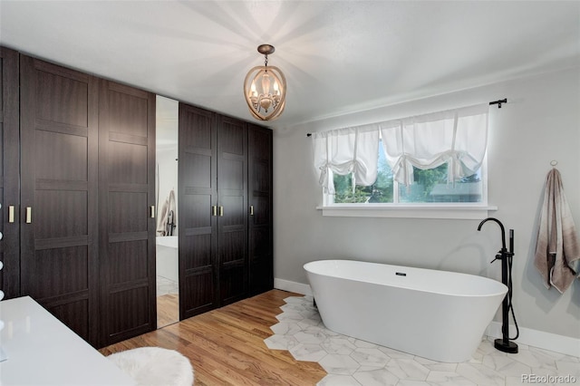 5332 W Roxbury Pl, Littleton, CO 80128 - full bath with a closet, baseboards, a soaking tub, and a chandelier