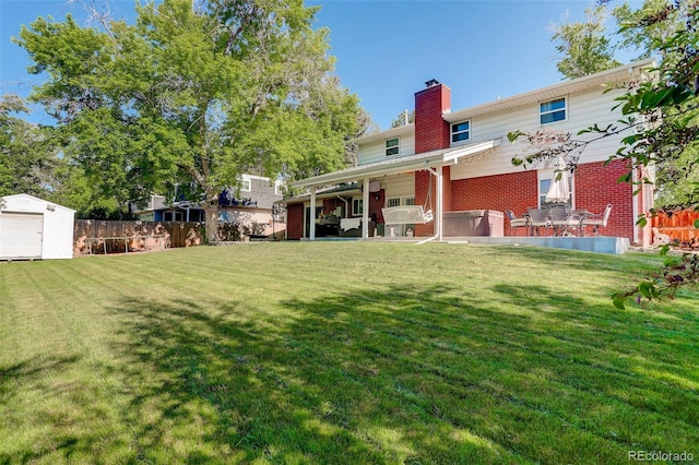 5332 W Roxbury Pl, Littleton, CO 80128 - rear view of property featuring brick siding, a chimney, and a patio area