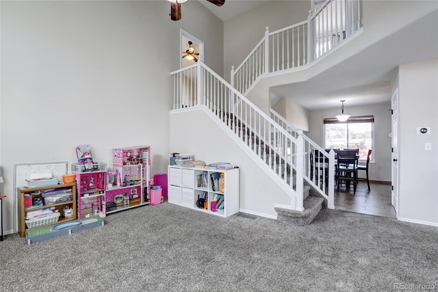 rec room with carpet flooring, a high ceiling, and ceiling fan