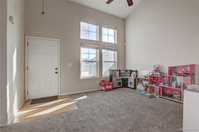 rec room with ceiling fan, carpet floors, and high vaulted ceiling