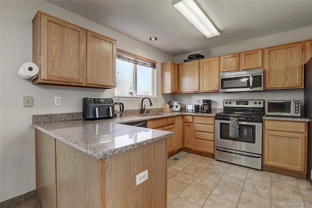 kitchen with sink, light tile patterned floors, light stone countertops, light brown cabinetry, and appliances with stainless steel finishes