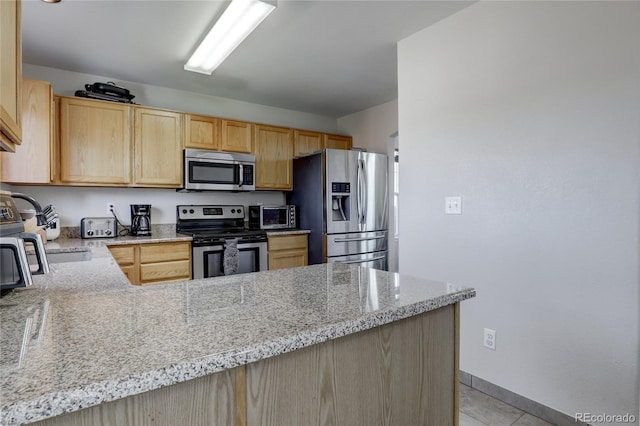 kitchen featuring kitchen peninsula, light stone countertops, light brown cabinets, and stainless steel appliances