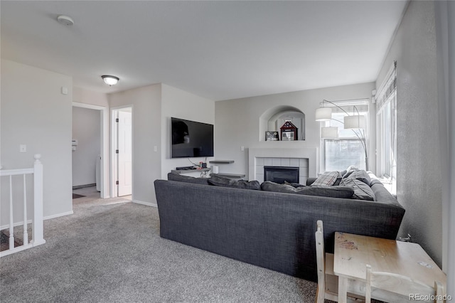 living room with a tiled fireplace and carpet floors