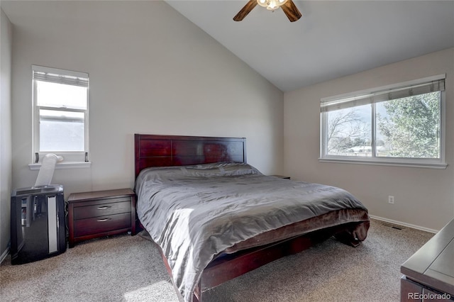 bedroom with ceiling fan, multiple windows, light carpet, and vaulted ceiling