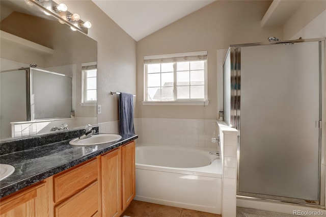 bathroom with tile patterned floors, separate shower and tub, vanity, and vaulted ceiling