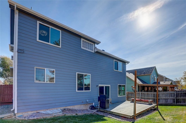 rear view of property featuring a wooden deck and a yard