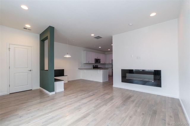 15443 W 65th Ave Unit B, Arvada, CO 80007 - unfurnished living room featuring light wood finished floors and recessed lighting