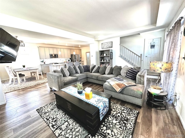 living area with stairs and wood finished floors