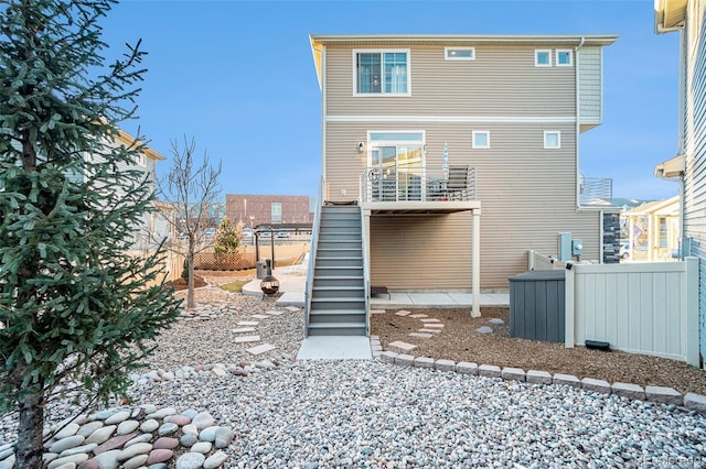 rear view of property with stairway and fence