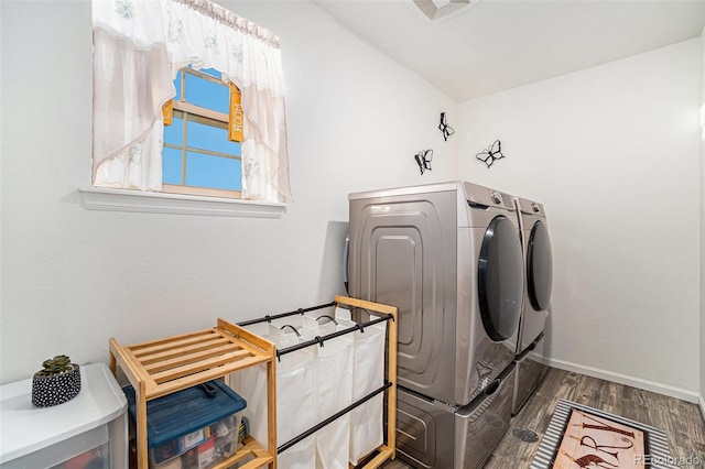 washroom with visible vents, wood finished floors, baseboards, laundry area, and washing machine and clothes dryer