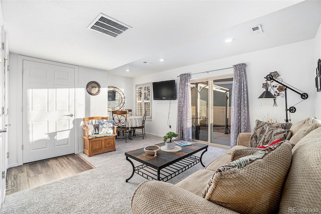 living area with recessed lighting, visible vents, and carpet flooring