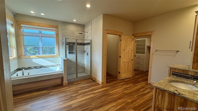 bathroom with vanity, shower with separate bathtub, and hardwood / wood-style floors