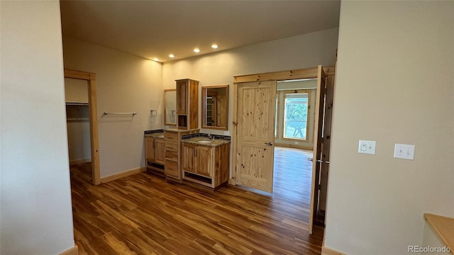 kitchen with baseboards, recessed lighting, a sink, and dark wood-style floors