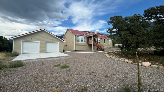 view of front of house featuring a garage and an outbuilding