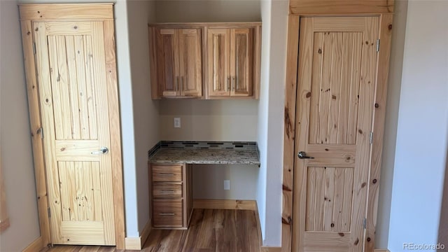 interior space featuring hardwood / wood-style flooring, light brown cabinetry, and light stone counters