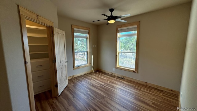 spare room with plenty of natural light, dark hardwood / wood-style floors, and ceiling fan