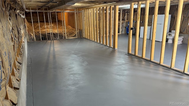 basement featuring white refrigerator and washer / clothes dryer