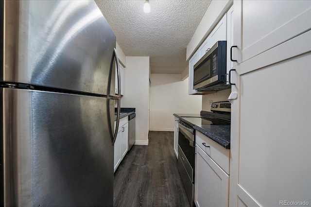 kitchen with white cabinets, dark countertops, dark wood-type flooring, stainless steel appliances, and a textured ceiling