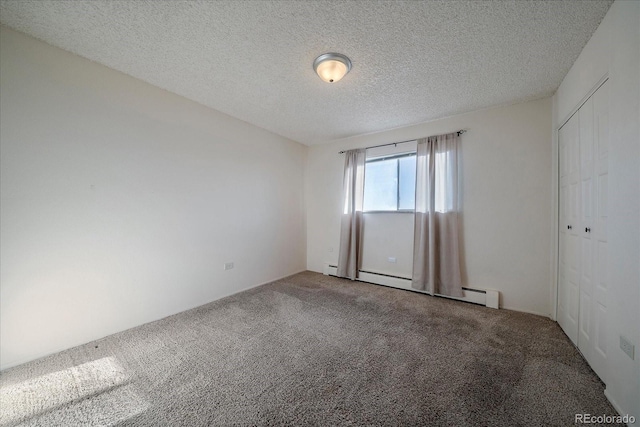 spare room with carpet floors, baseboard heating, and a textured ceiling