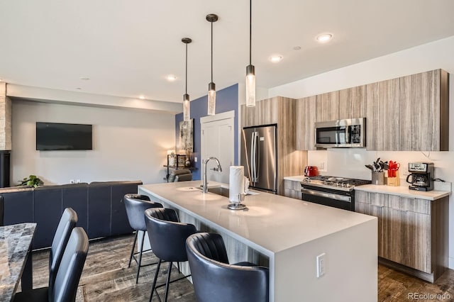 930 Blue River Pkwy Unit 812, Silverthorne, CO 80498 - kitchen with an island with sink, modern cabinets, light countertops, dark wood finished floors, and stainless steel appliances