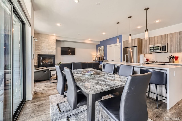 930 Blue River Pkwy Unit 812, Silverthorne, CO 80498 - dining area featuring light wood-type flooring, recessed lighting, and a fireplace