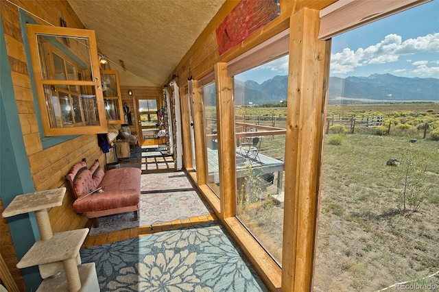 sunroom featuring a mountain view, a rural view, and vaulted ceiling