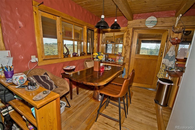 dining area with wood ceiling, light hardwood / wood-style flooring, and beamed ceiling