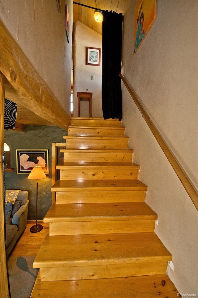 stairway featuring vaulted ceiling and hardwood / wood-style floors