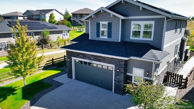 craftsman house featuring a garage and a front lawn