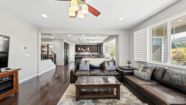 living room featuring dark wood-type flooring and ceiling fan