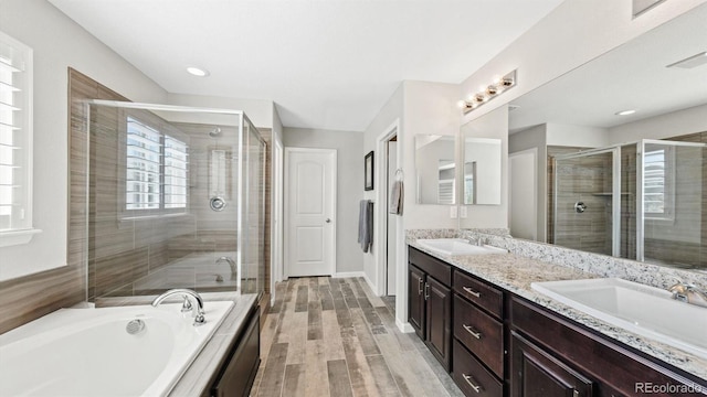 bathroom with independent shower and bath, vanity, and hardwood / wood-style floors