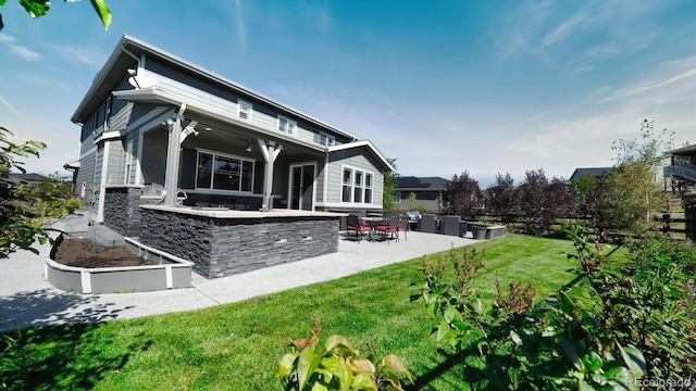 rear view of house featuring a yard, an outdoor bar, and a patio area